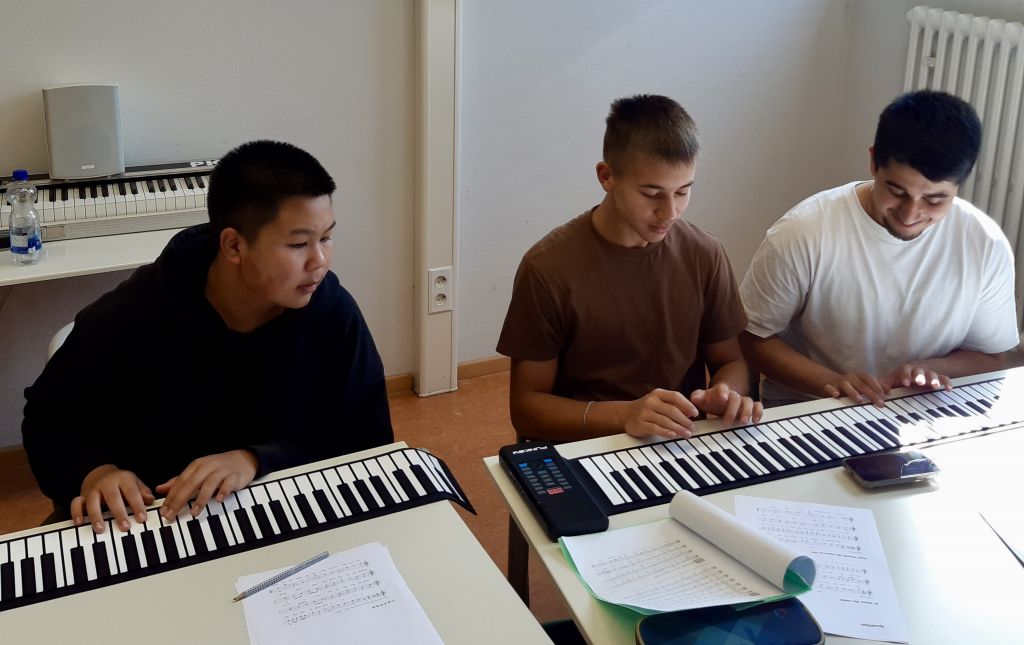 Schüler arbeiten mit Rollpianos im Musikunterricht