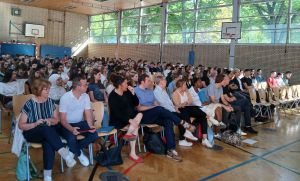 Dieses Bild zeigt die neuen Klassenlehrkräfte und Schülerinnen und Schüler des Burggymnasiums Friedberg bei ihrer Einschulungsfeier in der Sporthalle.
