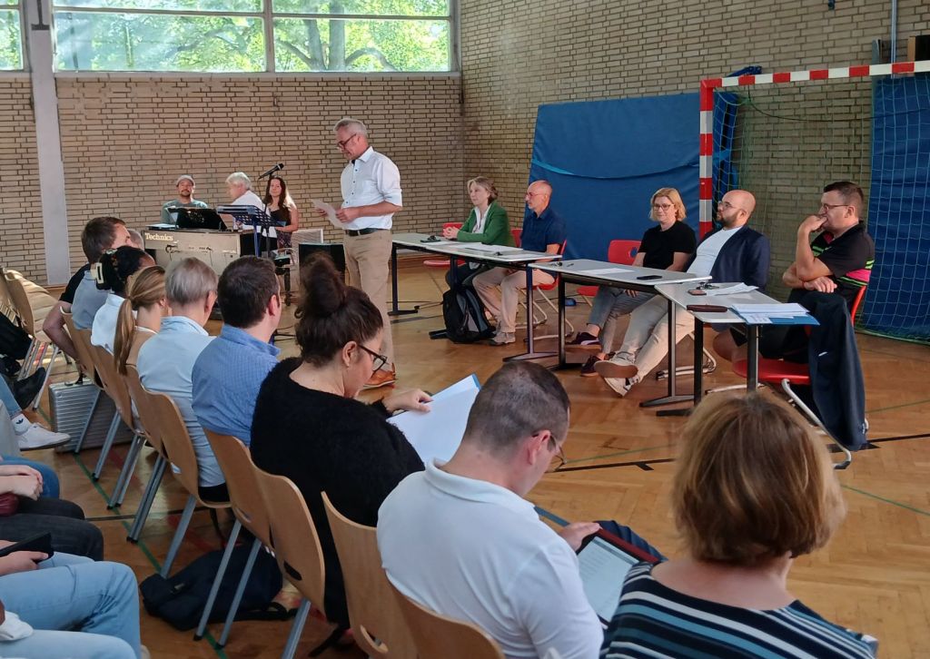 Dieses Bild zeigt die Schulleitung des Burggymnasiums Friedberg bei der Einschulungsfeier der neuen E-Phase in der Sporthalle.