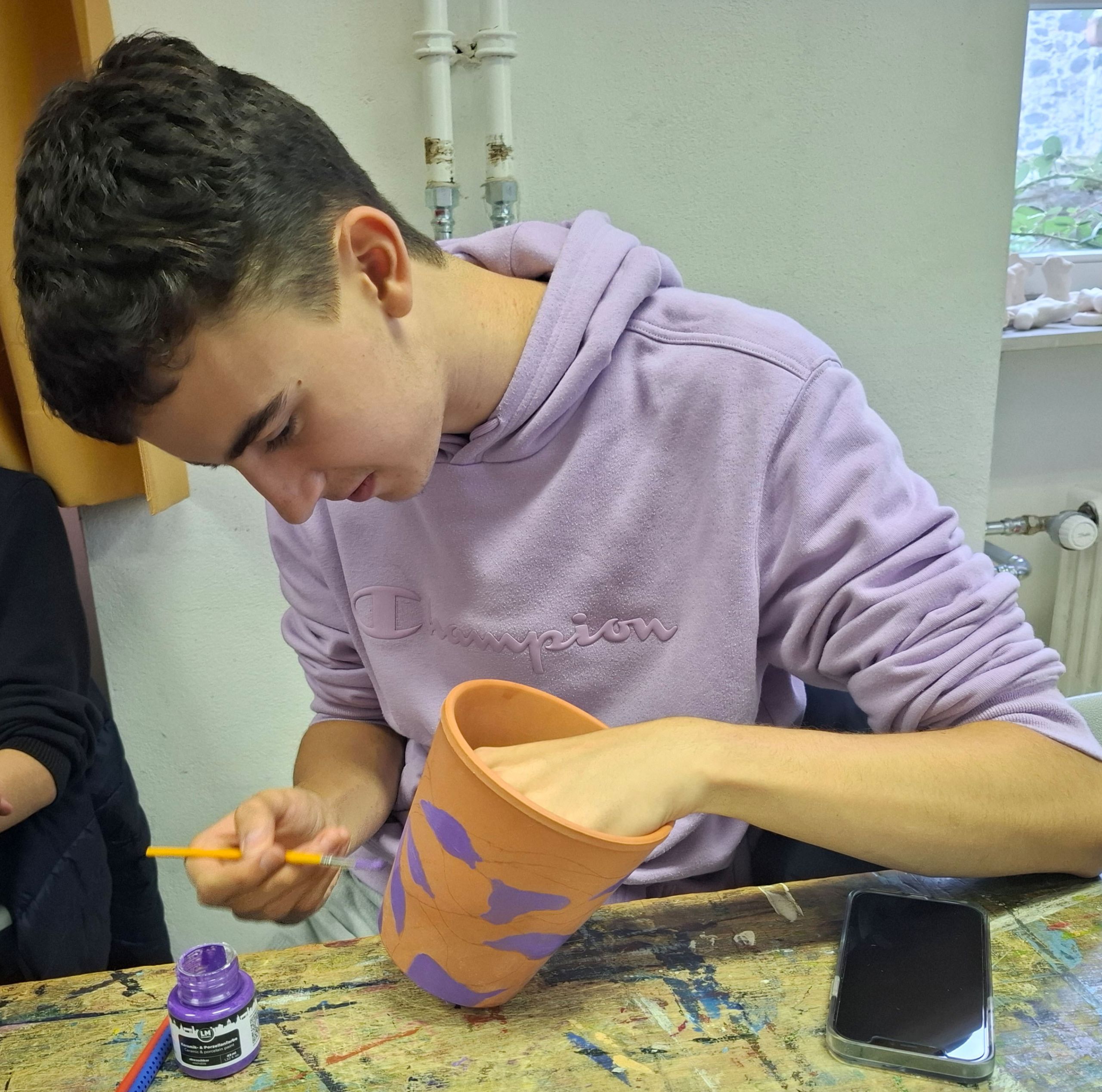 Dieses Bild zeigt einen Teilnehmenden am Upcycling-Workshop bei der kreativen Arbeit.