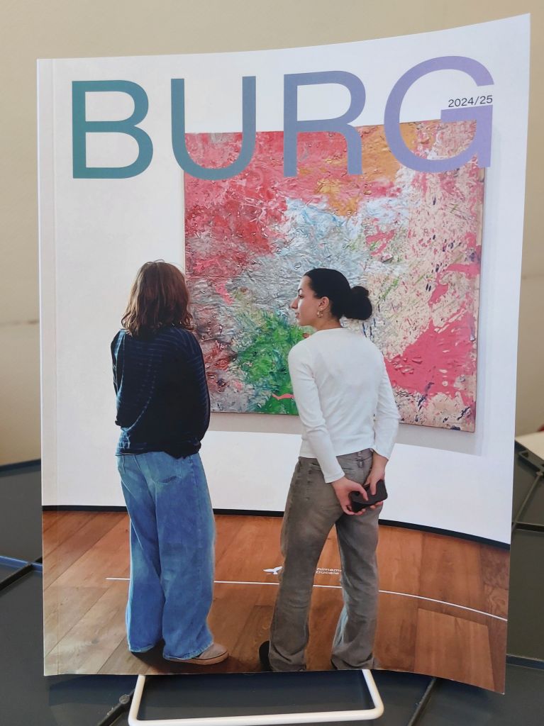 Auf diesem Foto sieht man ein Exemplar des Jahrbuchs des Burggymnasiums 2024-25.