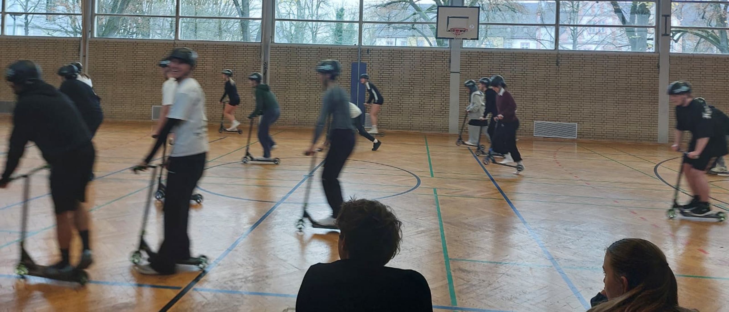 Das Bild zeigt die Rollerfahrenden in Bewegung.