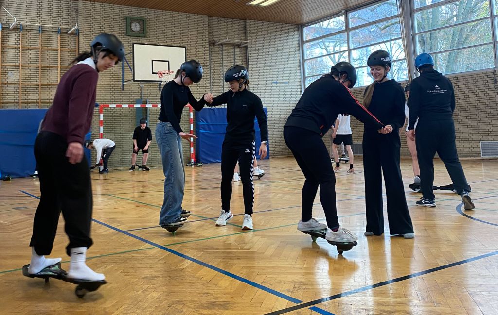 Das Bild zeigt Schülerinnen auf dem Waveboard.