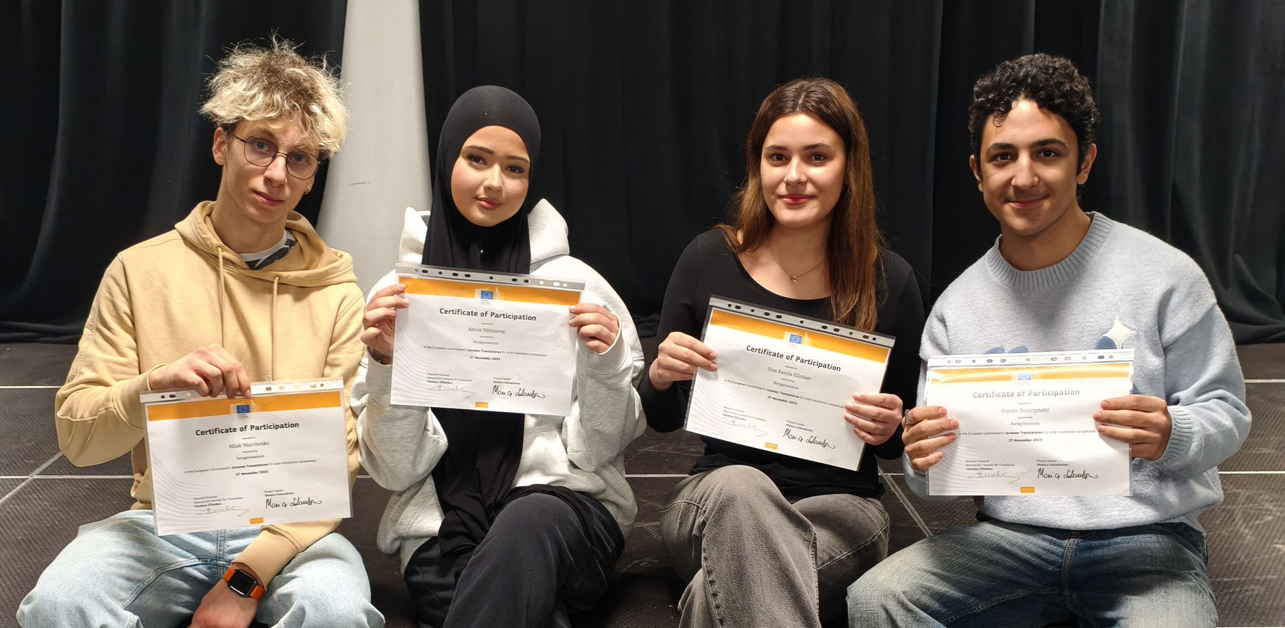 Das Foto zeigt die Teilnehmenden am Übersetzungswettbewerb mit ihren Teilnahmebescheinigungen.