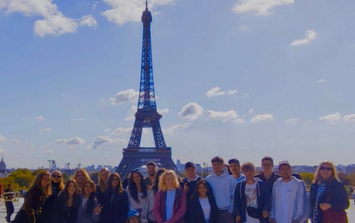 Das Bild zeigt die Reisegruppe der Studienfahrt nach Paris vor dem Eiffelturm.
