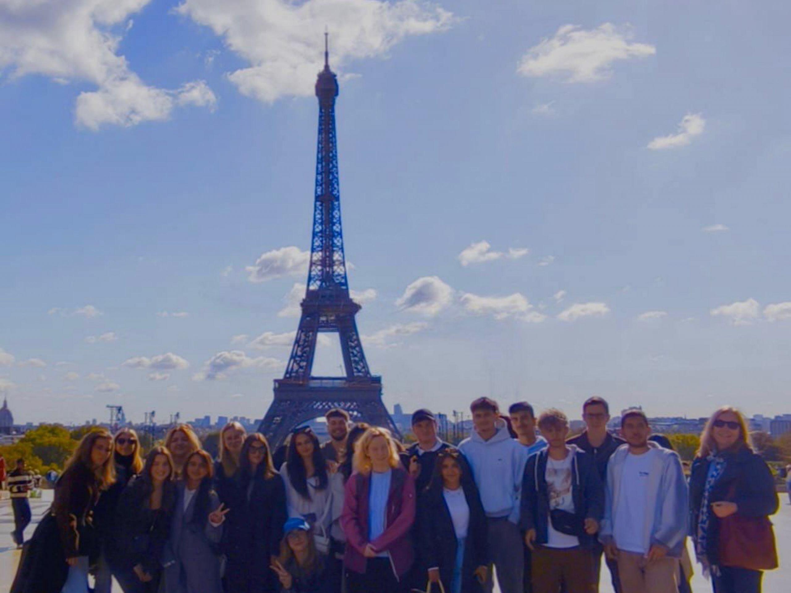 Das Bild zeigt die Reisegruppe der Studienfahrt nach Paris vor dem Eiffelturm.