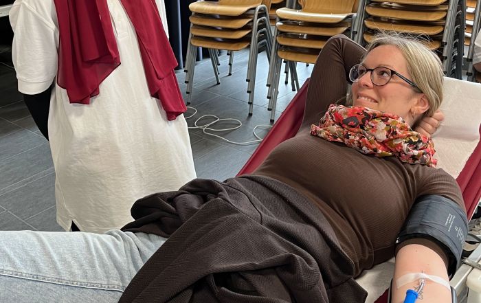 Auf diesem Foto sieht man eine blutspendende Lehrkraft in guten Händen des Schulsanitätsdienstes.