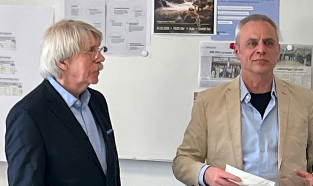 Auf diesem Bild sieht man den Künstler Kurt Schönewolf und den Schulleiter Ingo Baumgarten beim Festakt zur Übergabe des Faust-Bilderzyklus.