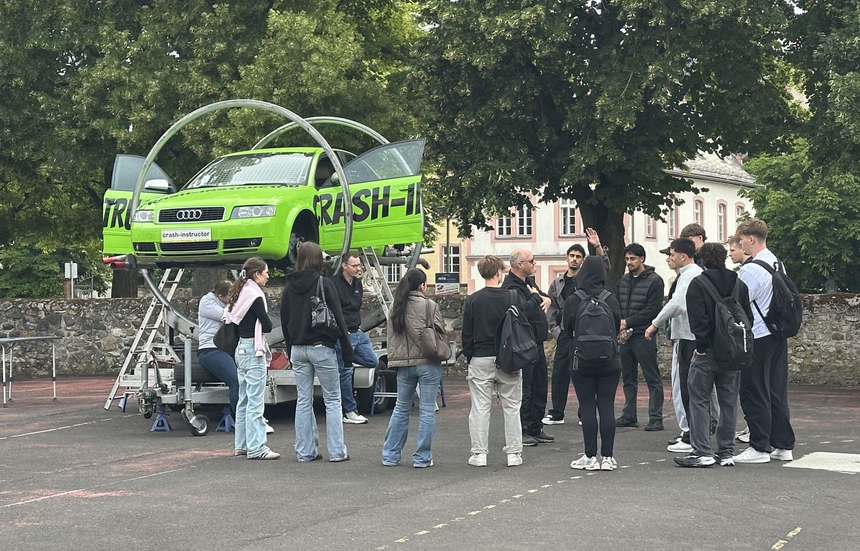 Schülerinnen und Schüler des Burggymnasiums Friedberg nehmen an einem Verkehrssicherheitstraining mit Crash-Instructor-Überschlagsimulator teil.
