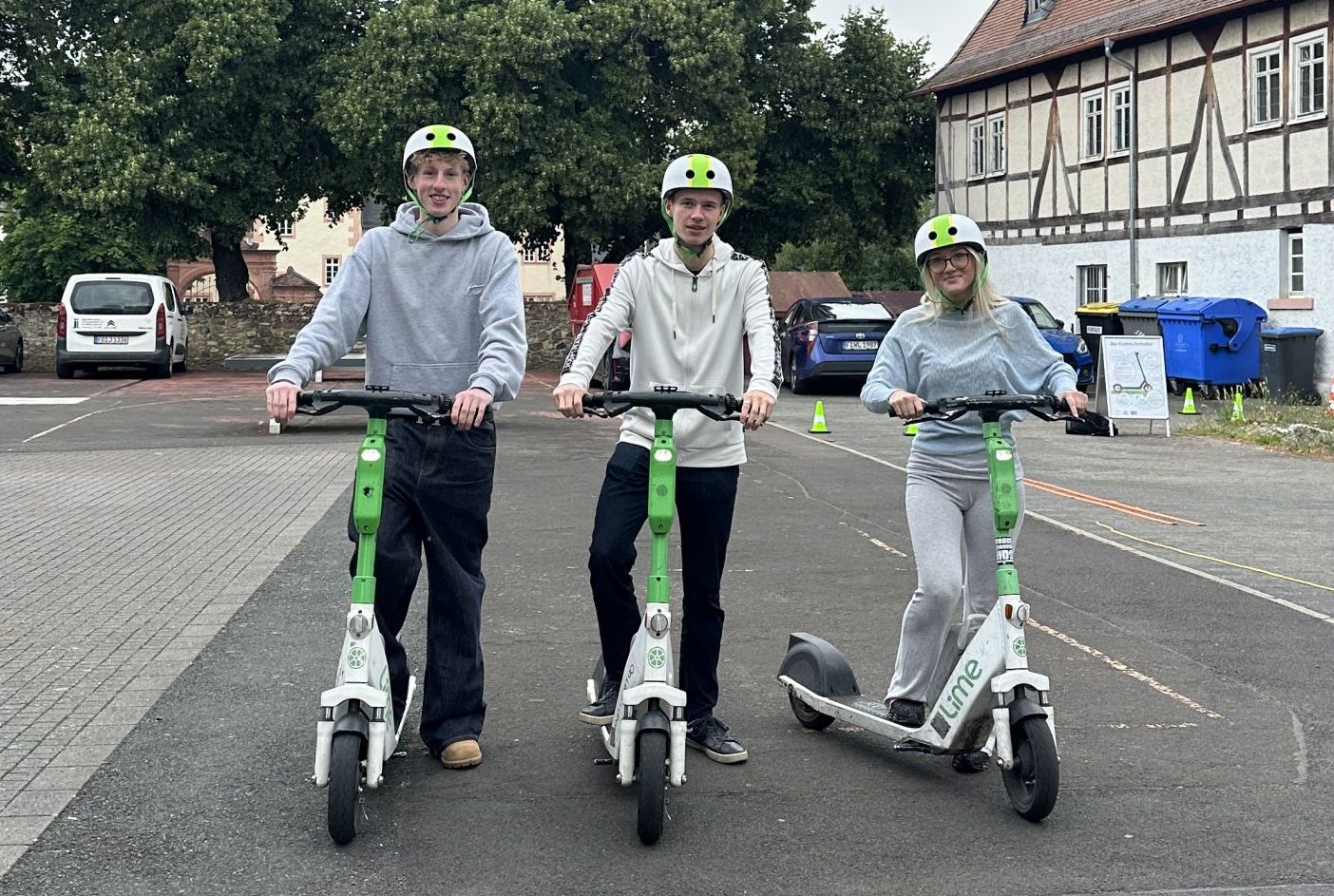 Schülerinnen und Schüler des Burggymnasiums Friedberg mit Helmen auf E-Scootern beim Sicherheitstraining