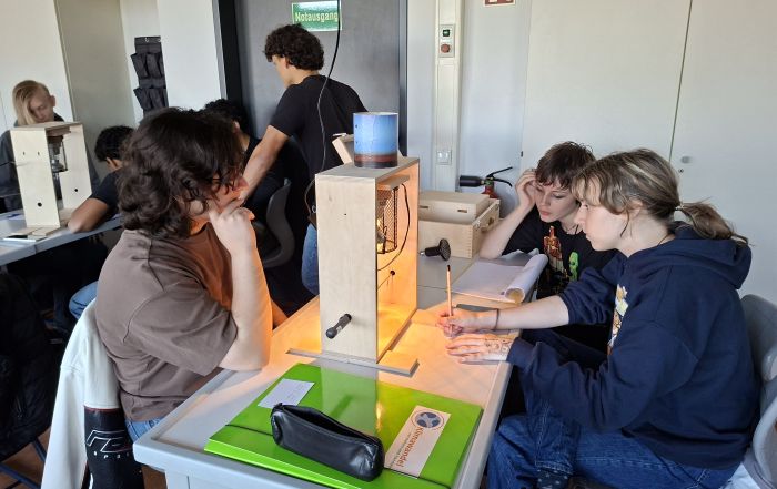 Schülerinnen und Schüler experimentieren mit einem Klimakoffer zur Wärmestrahlung.