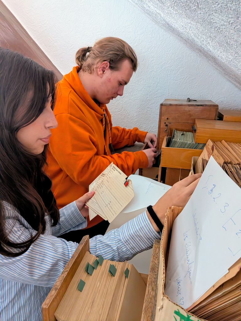 Schülerinnen und Schüler bei der Arbeit mit historischen Schulakten im Schularchiv des Burggymnasiums Friedberg